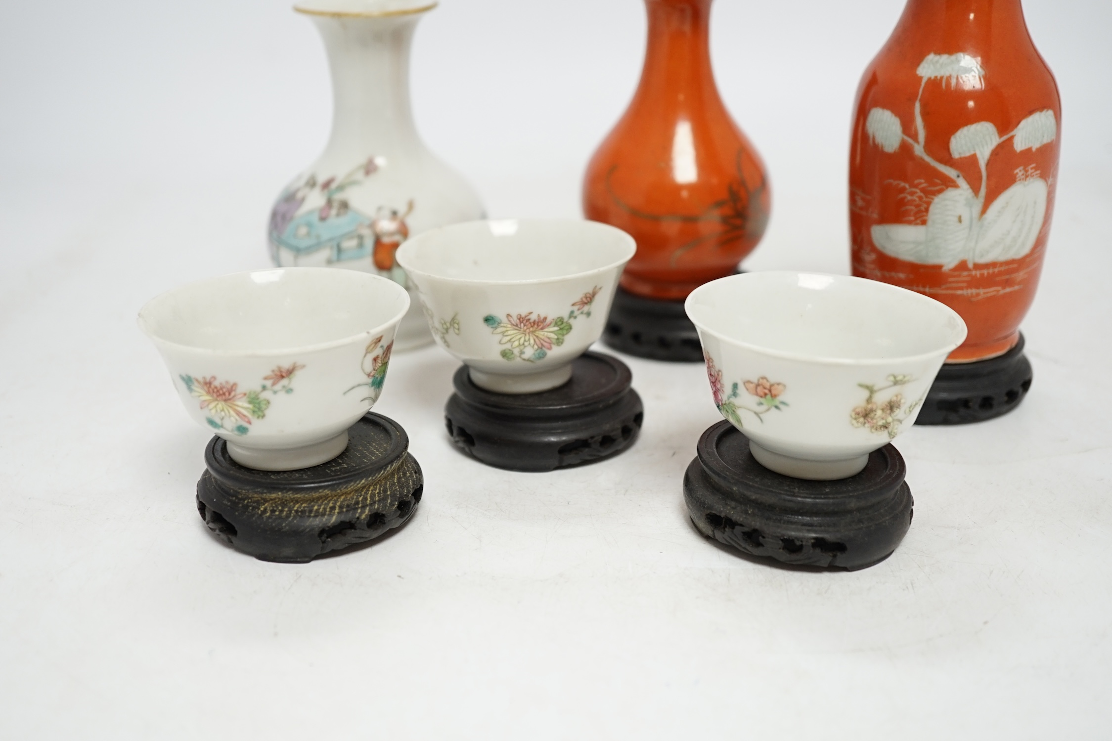 Six Chinese miniature porcelain vases and tea bowls, with wood stands, largest overall 15cm high. Condition - poor to fair